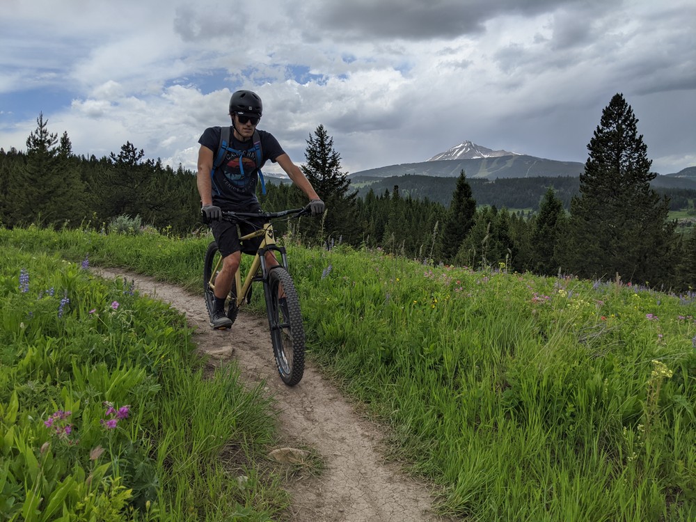 Mountain biking on a rock feature with an overlook of a forest below