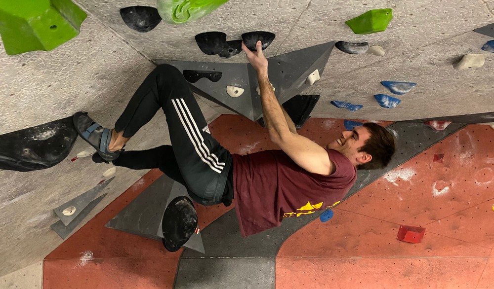 Climbing an artificial boulder problem at an indoor rock climbing facility